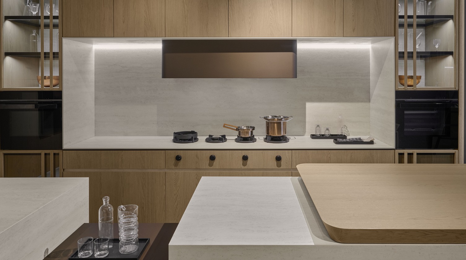 Composit Materya kitchen with oak cabinetry and pale stone surfaces